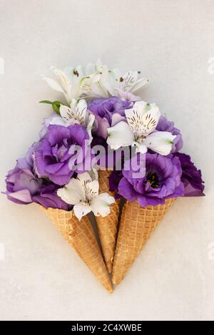 Immagine dall'alto del cono gelato con lisianto viola e. lillies bianchi Foto Stock