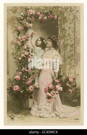 Primi anni '900 francese sentimentale tinta cartolina saluti - madre e figlia carina - la madre sta tenendo sua figlia fino a raccogliere rose, Francia, circa 1912 Foto Stock