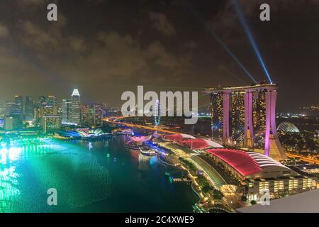 Singapore - CIRCA 2020: Skyline di Marina Bay, vista del Museo d'Arte, famoso hotel e Singapore Flyer durante la notte con un cielo tempestoso sul backgrou Foto Stock