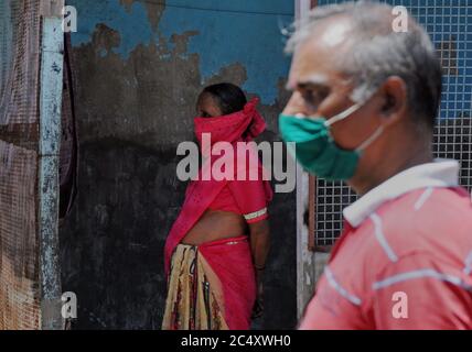 Mumbai, India. 29 Giugno 2020. Uomo e donna che indossano maschere facciali sono visti all'interno di una colonia di baraccopoli durante il test Covid-19.il governo Maharashtra ha esteso il blocco del coronavirus (COVID-19) fino a luglio 31 in mezzo a una crescita costante nei numeri infettati COVID-19 all'interno dello stato. I movimenti per attività non essenziali saranno limitati all'interno dei quartieri. Credit: SOPA Images Limited/Alamy Live News Foto Stock