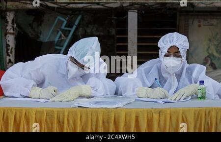 Mumbai, India. 29 Giugno 2020. Gli operatori sanitari vestiti con tute di protezione individuale (PPE) sono visti prendere appunti.il governo Maharashtra ha esteso il blocco del coronavirus (COVID-19) fino al luglio 31 in mezzo alla crescita costante dei numeri COVID-19 infetti all'interno dello stato. I movimenti per attività non essenziali saranno limitati all'interno dei quartieri. Credit: SOPA Images Limited/Alamy Live News Foto Stock