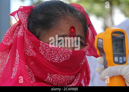 Mumbai, India. 29 Giugno 2020. Una donna indiana che indossa una maschera ottiene la sua temperatura scannered.The governo Maharashtra ha esteso il coronavirus (COVID-19) blocco fino a luglio 31 in mezzo alla crescita costante nei numeri COVID-19 infetti all'interno dello stato. I movimenti per attività non essenziali saranno limitati all'interno dei quartieri. Credit: SOPA Images Limited/Alamy Live News Foto Stock