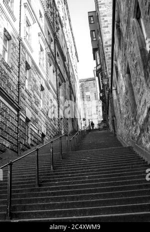 Uno dei molti vicoli stretti, conosciuto come un vicino, nella città vecchia di Edimburgo, fotografato in monocromo Foto Stock