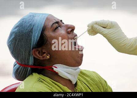 Mumbai, India. 29 Giugno 2020. Una donna apre la bocca per un campione di tampone durante il test di Covid-19.il governo Maharashtra ha esteso il blocco del coronavirus (COVID-19) fino al luglio 31 in mezzo alla crescita costante nei numeri infettati di COVID-19 all'interno dello stato. I movimenti per attività non essenziali saranno limitati all'interno dei quartieri. Credit: SOPA Images Limited/Alamy Live News Foto Stock