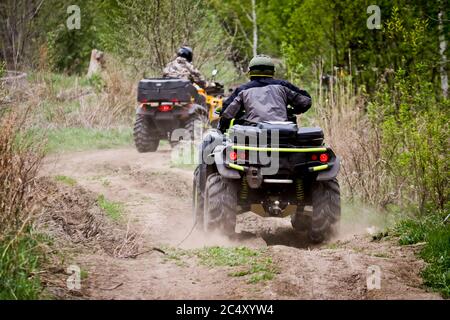 Messa a fuoco selettiva. Due piloti su ATV si guidano su una strada sterrata. Il concetto di attività all'aperto e sport estremi. Foto Stock
