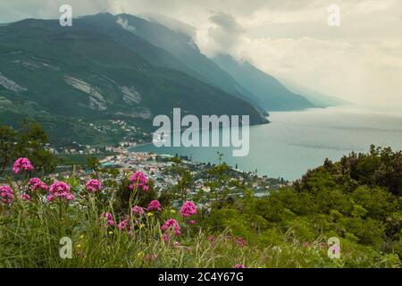 Vista panoramica su Torbole (lago del garda, Trentino, Italia) da Monte Brione in una giornata nuvolosa piovosa; perdita finanziaria nel turismo a causa della camera d'albergo vuota Foto Stock