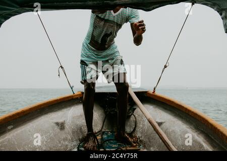 Un giovane pescatore locale si trova all'arco del suo tinny tiene stretto Foto Stock