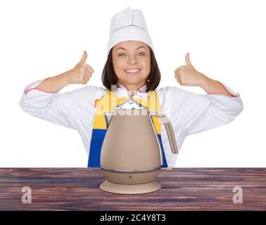 Bella giovane donna Chef Show Thumbs Up vicino Teapot moderno o bollitore elettrico su uno sfondo bianco Foto Stock