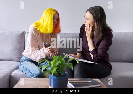 Ragazza teen che dà l'intervista al lavoratore sociale. Psicologo scolastico che parla con lo studente Foto Stock