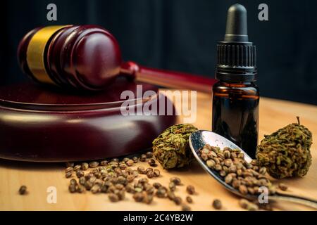 Semi di cannabis, gemme e olio del cbd su sfondo scuro con gavel. Concetto di legge di legalizzazione. Foto Stock