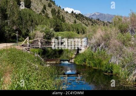 Vecchio ponte in legno di rickety sopra il torrente di roccia inferiore sotto la diga di Long Valley e il lago Crowley Foto Stock