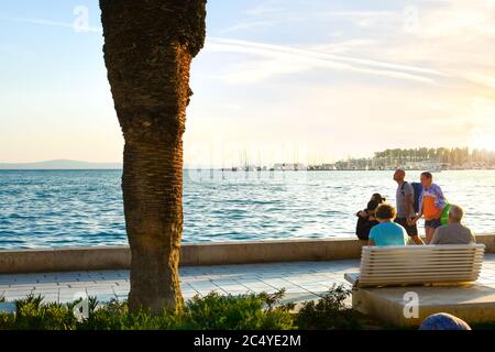 I turisti potranno godersi una passeggiata al tramonto lungo il lungomare Riva Promenade, nell'antica città di Spalato, Croazia, sulla costa della Dalmazia. Foto Stock