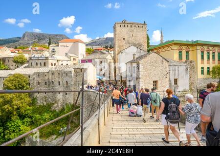 Una folla di turisti attraversare il restaurato ponte di Mostar nella città di Mostar, Bosnia, mentre si fanno strada nella città vecchia sezione. Foto Stock