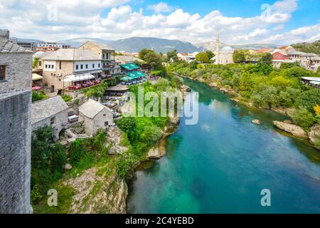 Caffetterie, i minareti e le moschee lungo il fiume Neretva nella città vecchia di Mostar, Bosnia e Herzegovinia. Preso dal vecchio ponte di Mostar a metà pomeriggio Foto Stock