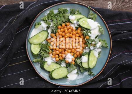 Insalata vegetariana sana con ceci arrostiti, kale, cetriolo e condimento. Disintossicazione sana. Cibo vegetariano e vegano. Foto Stock