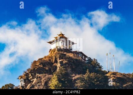 Piccola casa tradizionale Bhutanese e bandiere bianche di preghiera buddista alte nelle montagne Himalaya vicino alla città di Paro sulla strada per Taktshang Goemba o Tiger NE Foto Stock