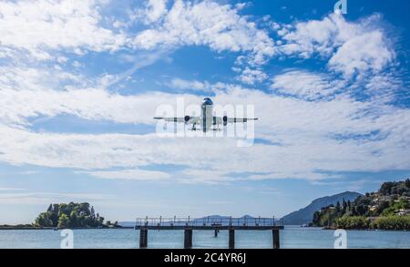 Atterraggio aereo all'aeroporto di Kerkyra Ioannis Kapodistrias, Corfy, Grecia. Pontikonisi 'Mouse Island' sulla sinistra. L'aereo sta atterrando proprio sopra Foto Stock