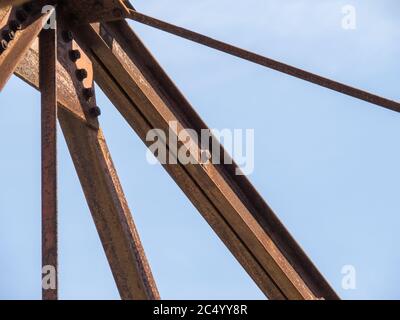 Primo piano di travi del tetto in acciaio su una vecchia fabbrica sito su uno sfondo blu cielo Foto Stock