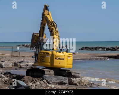 Toronto Canada, 1 aprile 2020; un piccolo Kobelco caterpillar ha tracciato rocce che si muovono in un progetto di ricostruzione della spiaggia Foto Stock