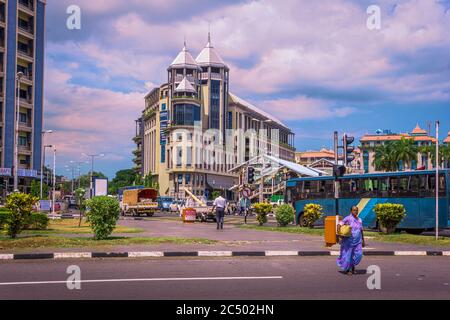 Port Louis Capital, Mauritius, Dicembre 2015 - Vista di donna rivestita in sari attraversamenti la strada di fronte al centro commerciale Caudan Waterfront Foto Stock