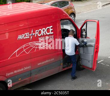 Un driver di consegna per la società logistica Parcel Force che fa parte di Royal Mail entrando nel furgone di consegna dopo aver fatto una consegna. Foto Stock