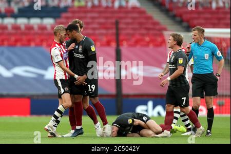 L'arbitro Michael Salisbury soffia il suo fischio prima che Dean Moxey di Exeter City (all'estrema sinistra) venga mostrata la carta rossa per un brutto scontro su Ryan Watson di Northampton Town (8) durante la partita finale di due Play-Off di Sky Bet League al Wembley Stadium, Londra. Foto Stock