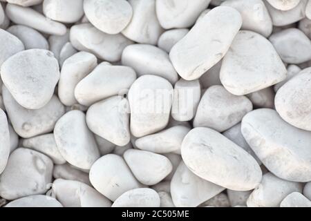 Fondo in ciottoli di roccia bianca lucidata naturalmente. Pietre bianche nel design. Foto Stock