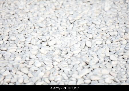 Fondo in ciottoli di roccia bianca lucidata naturalmente. Pietre bianche nel design. Foto Stock