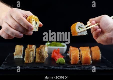 Il sushi con le mani e il salmone e l'anguilla Foto Stock