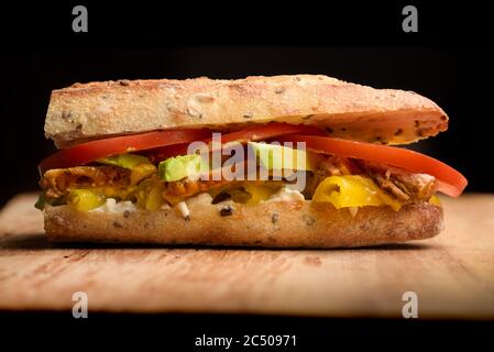 Sandwich di carne con avocado, pomodoro, mayo, peperoncino in baguette Foto Stock