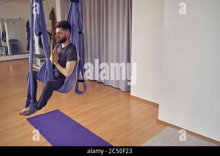 Bel giovane uomo che medita in studio di yoga Foto Stock