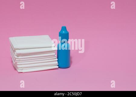 Tessuti bianchi e gocce di naso blu su sfondo rosa. Foto Stock
