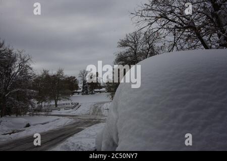 Grande tempesta di neve leggera e potente da 12 pollici a Littleton, Colorado, a sud di Denver, con auto coperta di neve profonda e strade piene di neve. Foto Stock