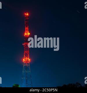 torre radio su sfondo cielo stellato notte, luci rosse, lunga esposizione Foto Stock