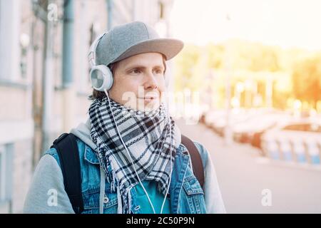 L'uomo caucasico con cappuccio grigio ascolta la musica sulle cuffie. Foto Stock