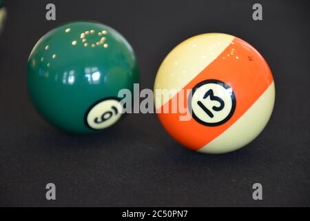 Palline da biliardo in un tavolo da biliardo nero, focalizzato su 13 palline Foto Stock