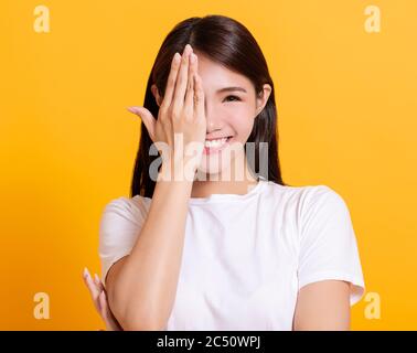 sorridente occhio di copertura mano giovane donna Foto Stock