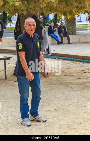 Cannes, Francia - 17 Ottobre 2013: Senior l'uomo gioca a bocce con una sfera di metallo in un parco Foto Stock