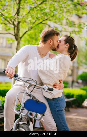 Giovane baciando uomo e donna in giardino pubblico Foto Stock