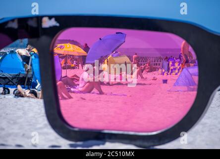 Zingst, Germania. 24 Giugno 2020. I grandi vetri rosa con il titolo 'Sea Pink II' di Marc Moser, mostra del festival fotografico 'Horizonte' 2016, sulla spiaggia del Mar Baltico. Con il sole e temperature intorno ai 25 gradi, molti turisti usano il tempo estivo per una giornata in spiaggia. Gli alberghi, le pensioni e i campeggi nelle regioni turistiche del Meclemburgo-Vorpommern sono attualmente molto ben utilizzati. Credit: Jens Büttner/dpa-Zentralbild/ZB/dpa/Alamy Live News Foto Stock