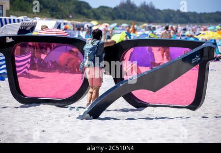 Zingst, Germania. 24 Giugno 2020. I grandi vetri rosa con il titolo 'Sea Pink II' di Marc Moser, mostra del festival fotografico 'Horizonte' 2016, sulla spiaggia del Mar Baltico. Con il sole e temperature intorno ai 25 gradi, molti turisti usano il tempo estivo per una giornata in spiaggia. Gli alberghi, le pensioni e i campeggi nelle regioni turistiche del Meclemburgo-Vorpommern sono attualmente molto ben utilizzati. Credit: Jens Büttner/dpa-Zentralbild/ZB/dpa/Alamy Live News Foto Stock