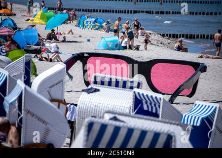 Zingst, Germania. 24 Giugno 2020. I grandi vetri rosa con il titolo 'Sea Pink II' di Marc Moser, mostra del festival fotografico 'Horizonte' 2016, sulla spiaggia del Mar Baltico. Con il sole e temperature intorno ai 25 gradi, molti turisti usano il tempo estivo per una giornata in spiaggia. Gli alberghi, le pensioni e i campeggi nelle regioni turistiche del Meclemburgo-Vorpommern sono attualmente molto ben utilizzati. Credit: Jens Büttner/dpa-Zentralbild/ZB/dpa/Alamy Live News Foto Stock