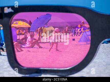 Zingst, Germania. 24 Giugno 2020. I grandi vetri rosa con il titolo 'Sea Pink II' di Marc Moser, mostra del festival fotografico 'Horizonte' 2016, sulla spiaggia del Mar Baltico. Con il sole e temperature intorno ai 25 gradi, molti turisti usano il tempo estivo per una giornata in spiaggia. Gli alberghi, le pensioni e i campeggi nelle regioni turistiche del Meclemburgo-Vorpommern sono attualmente molto ben utilizzati. Credit: Jens Büttner/dpa-Zentralbild/ZB/dpa/Alamy Live News Foto Stock