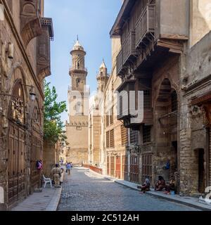 Cairo, Egitto - Giugno 26 2020: Moez Street con lavoratori, pochi visitatori locali e minareto del complesso storico Qalawun edificio, durante il periodo di blocco Covid-19, quartiere di Gamalia, il Cairo Vecchio