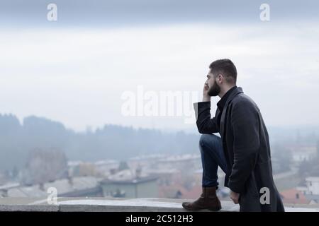 giovane uomo bearato sul tetto di un edificio Foto Stock