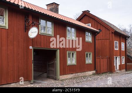 Case tradizionali in legno con profonde pitture rosse Falu o falun nel centro storico di Gamla Linkoping, Svezia Foto Stock