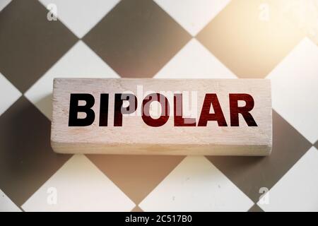Parola BIPOLARE su blocco di legno sulla scacchiera. Concetto di salute mentale Foto Stock