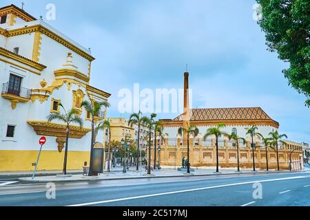 La vista sul Convento di Santo Domingo e l'alto camino in mattoni dell'ex fabbrica di tabacco, oggi che serve come Palazzo del Congresso, Cadice, Spagna Foto Stock