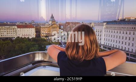 Una ragazza guarda dal taxi di una ruota panoramica di Budapest al centro della città. Occhio di Budapest Foto Stock