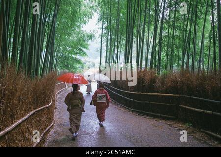 Kyoto, Giappone. 30 giugno 2020. Le Signore giapponesi indossano il tradizionale kimono camminano attraverso il famoso sentiero di bambù ad Arashiyama (uno dei punti di riferimento della vecchia capitale) il 30 giugno 2020 a Kyoto, Giappone. Il numero di visitatori stranieri in Giappone è sceso del 99.9% rispetto allo scorso anno e le restrizioni globali sui viaggi limitano severamente il trasporto internazionale di passeggeri in mezzo alla pandemia del coronavirus Covid-19. 30 giugno 2020 Credit: Nicolas Datiche/AFLO/Alamy Live News Foto Stock